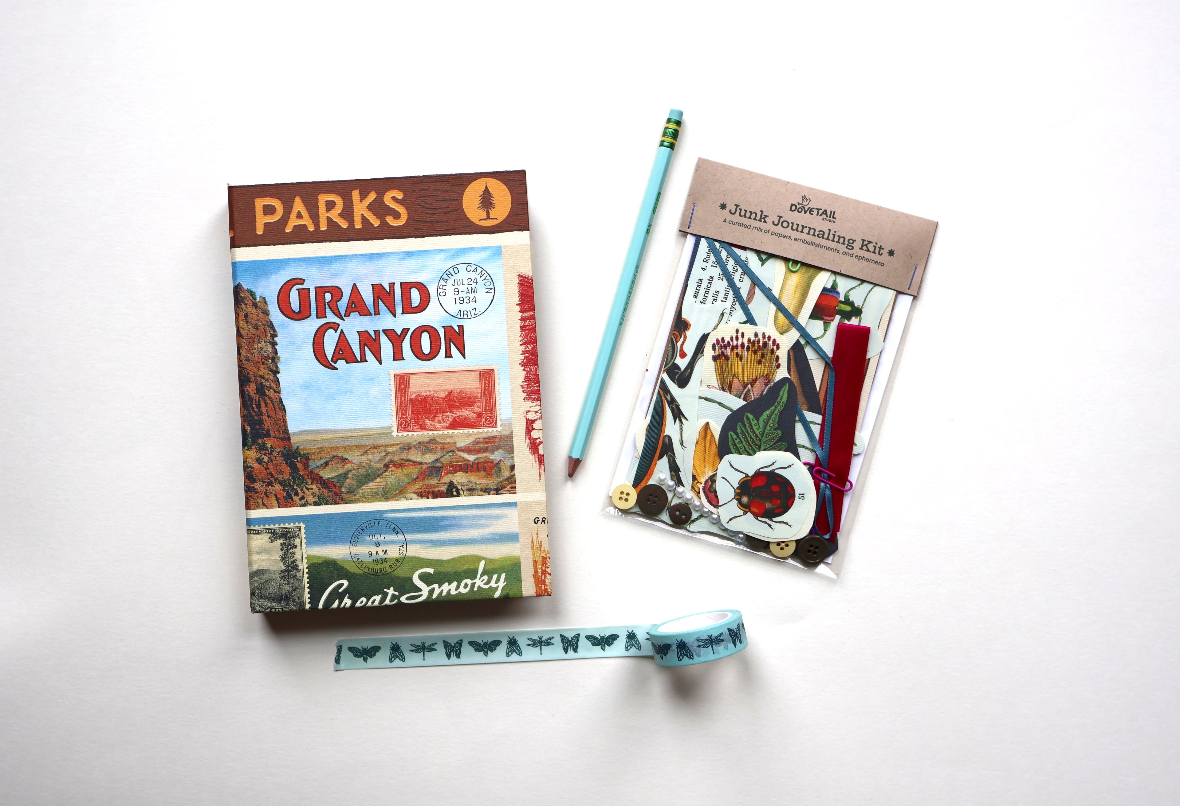 A flat-lay of a 'Parks Grand Canyon' sketchbook, a light blue pencil, insect-patterned washi tape, and a 'Junk Journaling Kit' on a white background.