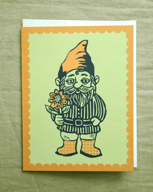Greeting card with an illustrated gnome holding a sunflower on a green background. made from riginal linocut design with envelope included