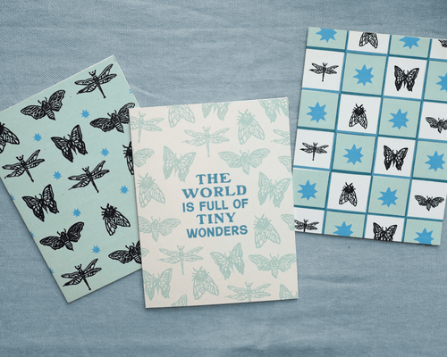 three incect greeting cards on a textured blue background