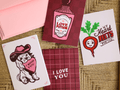 Greetings cards on brown background with pink dogs, red beet, love card, and pink envelopes