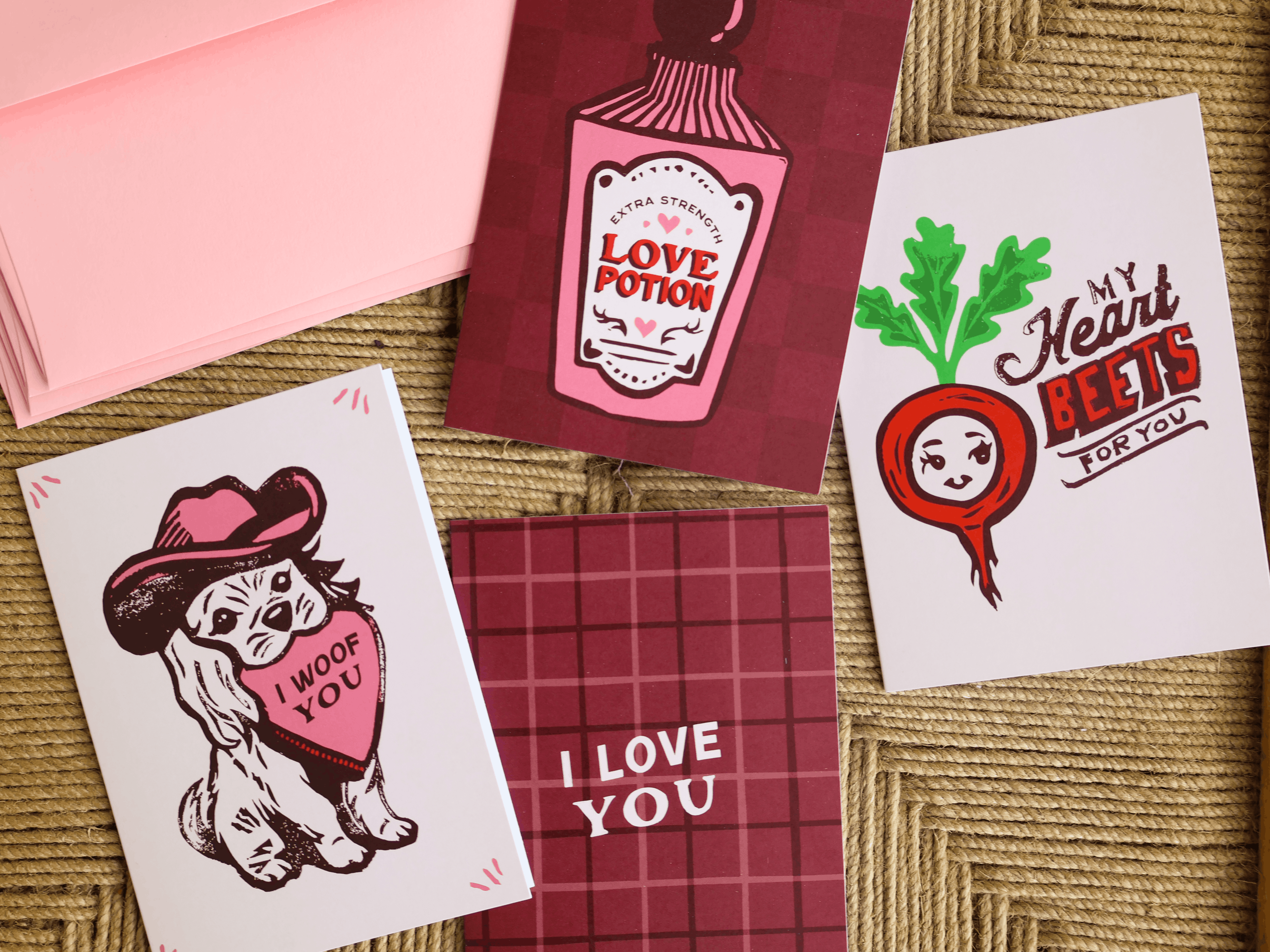 Greetings cards on brown background with pink dogs, red beet, love card, and pink envelopes