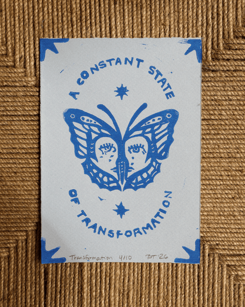 handmade linocut print with butterfly design and text 'A Constant State of Transformation' on a patterned background.