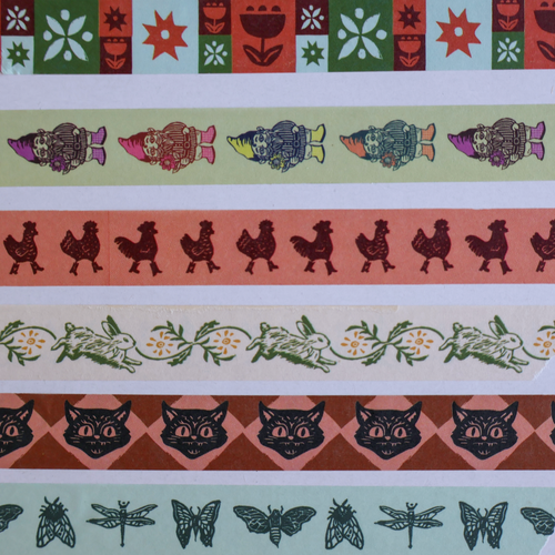 collection of washi tape designs across a plain white background. showing original linocut designs of florals, gnomes, chickens, bunnies, cats, and bugs for stationery